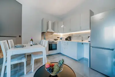 a kitchen with a table and a bowl of fruit on a table at Eramel Cozy Apartment with Sea View in Rhodes Town