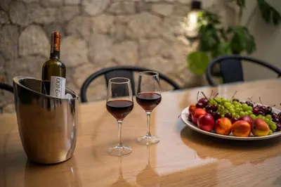 a table with two glasses of wine and a plate of fruit at Ocean Pearl Sea View in Faliraki