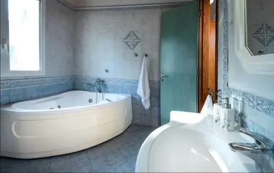 a bathroom with a large tub and a sink at villa Aphrodite Rhodes in Pastida