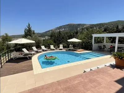 a swimming pool with two people in a swimming pool at villa Aphrodite Rhodes in Pastida