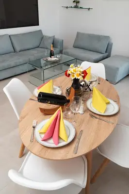 a wooden table with plates and napkins on it at Wohlfühloase 1 Casa Elena und Gerd in Rhodes Town