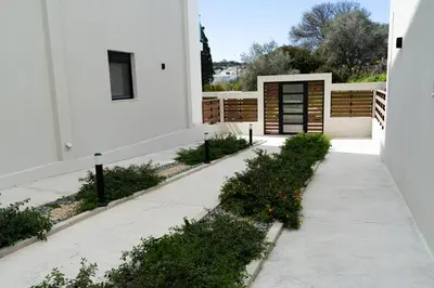 a white house with a sidewalk and plants at Wohlfühloase 1 Casa Elena und Gerd in Rhodes Town