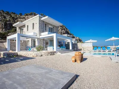 a house with a large vase in front of it at Villa in Rhodes with Infinity Pool & BBQ in Kalithies