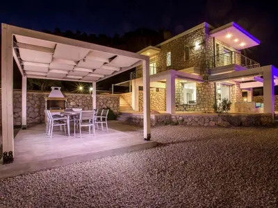 a patio with a table and chairs in front of a house at Villa in Rhodes with Infinity Pool & BBQ in Kalithies