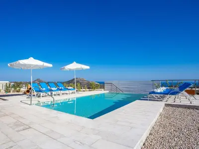 a swimming pool with chairs and an ocean view at Villa in Rhodes with Infinity Pool & BBQ in Kalithies