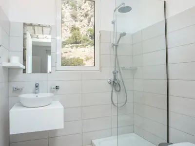 a white bathroom with a sink and a shower at Villa in Rhodes with Infinity Pool & BBQ in Kalithies