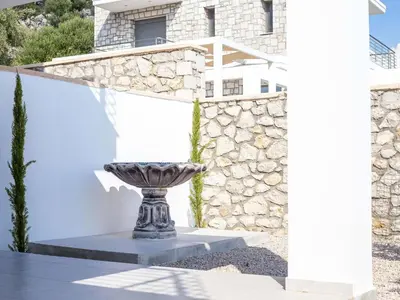 a statue in front of a building with a stone wall at Villa in Rhodes with Infinity Pool & BBQ in Kalithies