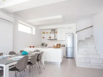 a kitchen and dining room with a table and a refrigerator at Villa in Rhodes with Infinity Pool & BBQ in Kalithies