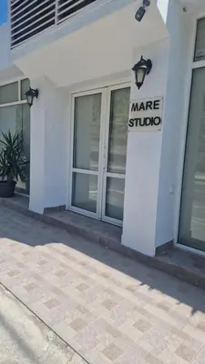 a white building with a market studio sign on it at Studio Mare Faliraki in Faliraki