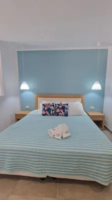 a bedroom with a large bed with a blue wall at Studio Mare Faliraki in Faliraki