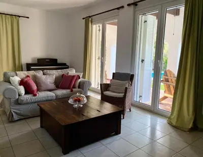 a living room with a couch and a coffee table at Villa Sofia with garden, pool and lounge areas in Kolimbia