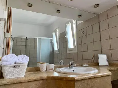a bathroom with a sink and a mirror at Villa Sofia with garden, pool and lounge areas in Kolimbia