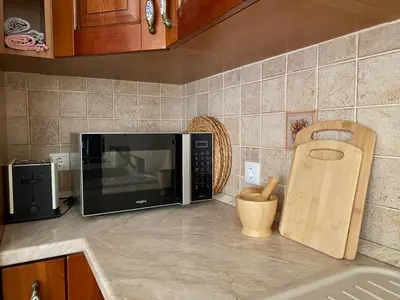 a kitchen counter with a microwave on a counter top at Villa Sofia with garden, pool and lounge areas in Kolimbia
