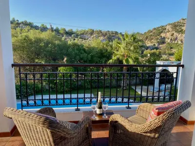 a balcony with two chairs and a table with a view at Villa Sofia with garden, pool and lounge areas in Kolimbia