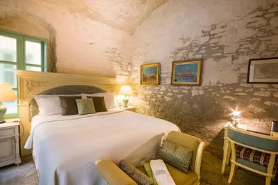 a bedroom with a large bed and two chairs at The Old Markets in Symi