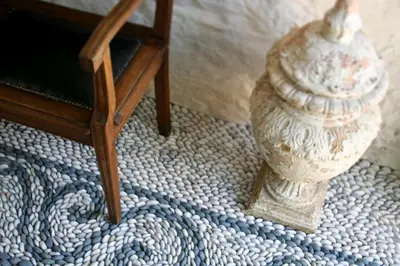 a vase sitting on the floor next to a chair at The Old Markets in Symi