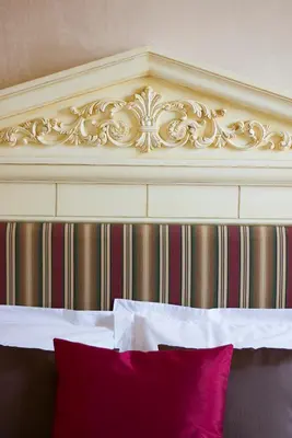 a headboard of a bed with a red pillow at The Old Markets in Symi