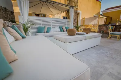 a living room with two white couches and an umbrella at The Old Markets in Symi