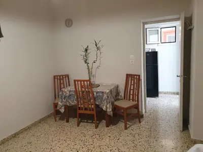 a dining room table with four chairs and a table with a table cloth at Yiannis Sokaki detached House in Rhodes Town