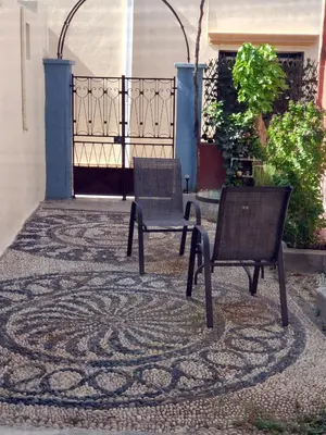 two chairs sitting on a rug in front of a gate at Yiannis Sokaki detached House in Rhodes Town