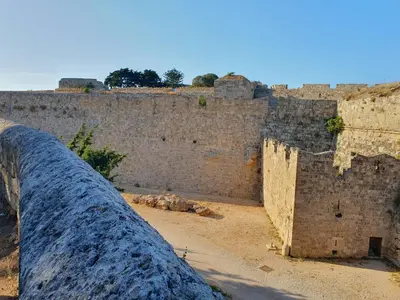 an old stone wall with a fence at Yiannis Sokaki detached House in Rhodes Town
