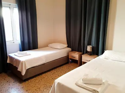 a hotel room with two beds and a window at Yiannis Sokaki detached House in Rhodes Town