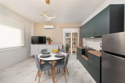 a kitchen with a table and chairs in a kitchen at Casa di Calma & Casa di Luce Rhodes Apartments in Rhodes Town