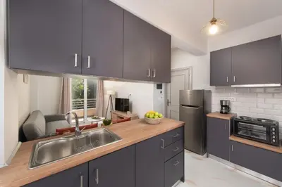 a kitchen with gray cabinets and a sink and a counter at Casa di Calma & Casa di Luce Rhodes Apartments in Rhodes Town