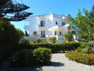 a white building with a garden in front of it at Villa Dora in Faliraki