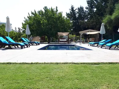 a swimming pool with lounge chairs and a bunch ofitures at Villa Dora in Faliraki