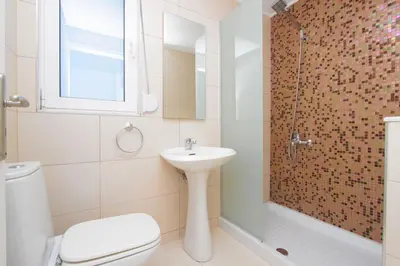 a bathroom with a sink and a toilet and a shower at Villa Dora in Faliraki