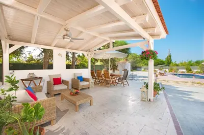 an outdoor patio with a wooden pergola at Villa Dora in Faliraki