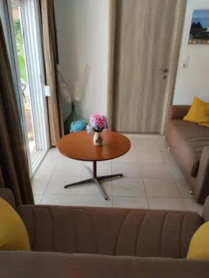 a living room with a table and a couch at Platanos Villa in Haraki