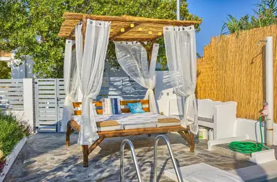 a gazebo with a bed on a patio at Platanos Villa in Haraki
