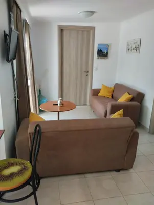 a living room with a couch and a table at Platanos Villa in Haraki