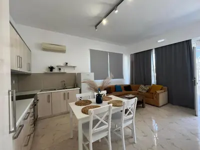 a kitchen and living room with a table and chairs at Nesèa Apartment Faliraki in Faliraki