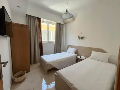 a hotel room with two beds and a tv at Nesèa Apartment Faliraki in Faliraki