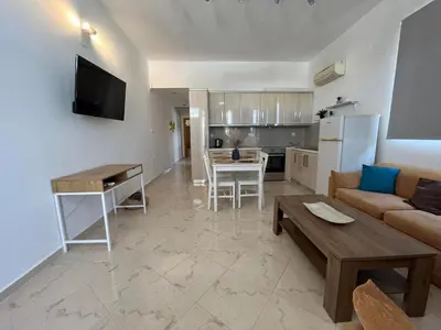 a living room with a couch and a table at Nesèa Apartment Faliraki in Faliraki