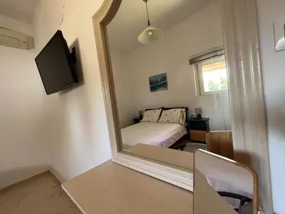 a mirror in a room with a bed and a bedroom at Nesèa Apartment Faliraki in Faliraki