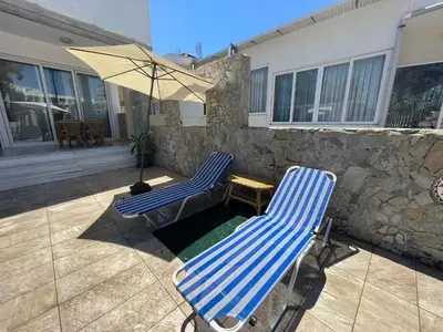 two blue chairs and an umbrella on a patio at Nesèa Apartment Faliraki in Faliraki
