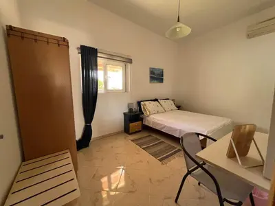 a bedroom with a bed and a table and a window at Nesèa Apartment Faliraki in Faliraki