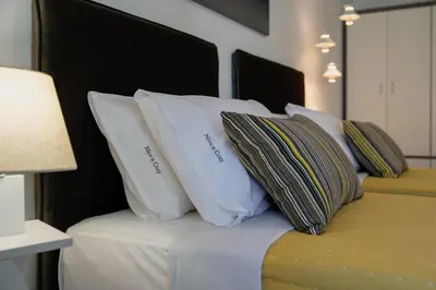 a bed with white pillows on top of it at Nice n Cosy Apartment I in Rhodes Town