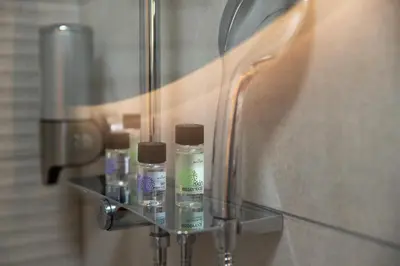 a group of bottles on a glass shelf in a bathroom at Nice n Cosy Apartment I in Rhodes Town