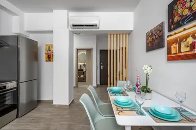 a kitchen and dining room with a white table and chairs at Nice n Cosy Apartment I in Rhodes Town