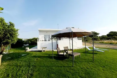 a group of chairs and an umbrella in a yard at Emerald Private Villa in Kalavarda Rhodes in Kalavárda