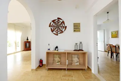 a living room with white walls and a wooden table at Emerald Private Villa in Kalavarda Rhodes in Kalavárda