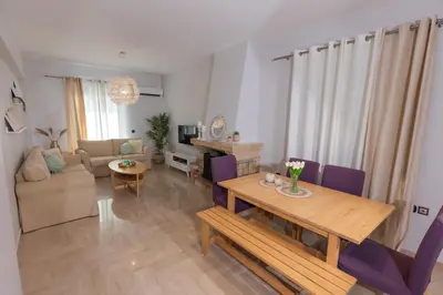 a living room with a wooden table and purple chairs at Silver Palm House Ixia, Rhodes in Ixia