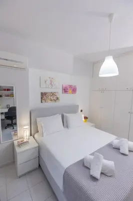 a white bedroom with a large white bed with two towels at Silver Palm House Ixia, Rhodes in Ixia