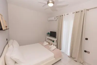 a white bedroom with a bed and a window at Silver Palm House Ixia, Rhodes in Ixia