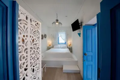 a bedroom with a white bed and a window at SUN PETRADI Tradition & Luxury in Koskinou